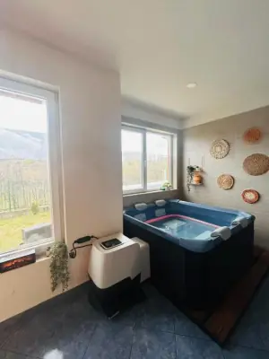 Indoor jetted tub with wooden surround and tiled walls