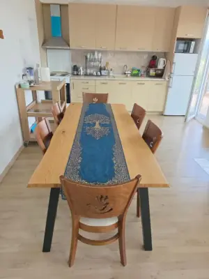 Open-plan kitchen and dining with wooden table and blue runner