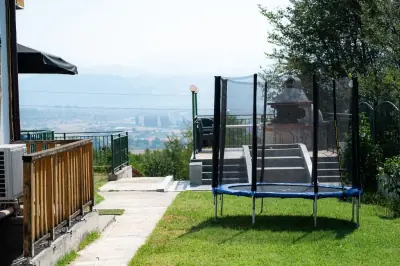 Outdoor patio with shaded dining, built-in barbecue and trampoline