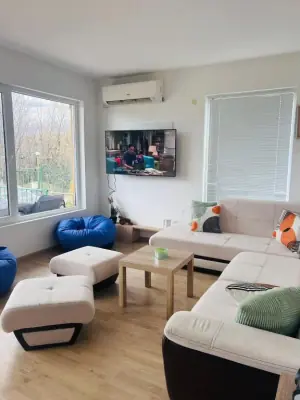 Living room with wall-mounted TV, wooden coffee table and blue bean bags