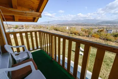 Wooden balcony with chairs overlooking mountain valley