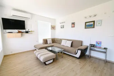 Living room with corner sofa, TV and glass coffee table