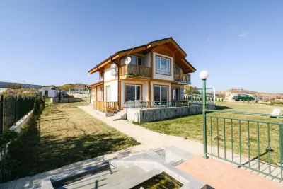 Two-story house with balcony, satellite dish and small pond