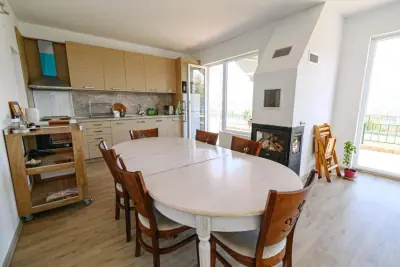 Kitchen and dining with fireplace and balcony access