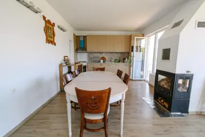Dining area with white table, chairs and wood-burning stove
