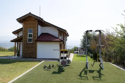 Outdoor gym equipment on artificial turf beside villa