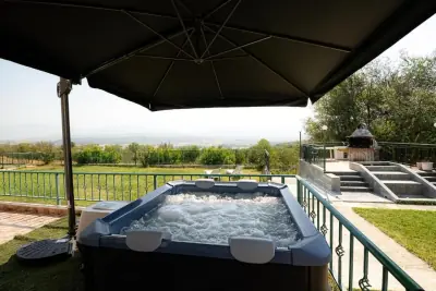 Outdoor bubbling jacuzzi with umbrella and mountain view