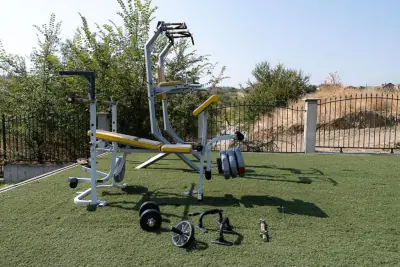 Outdoor fitness equipment with weights on artificial turf